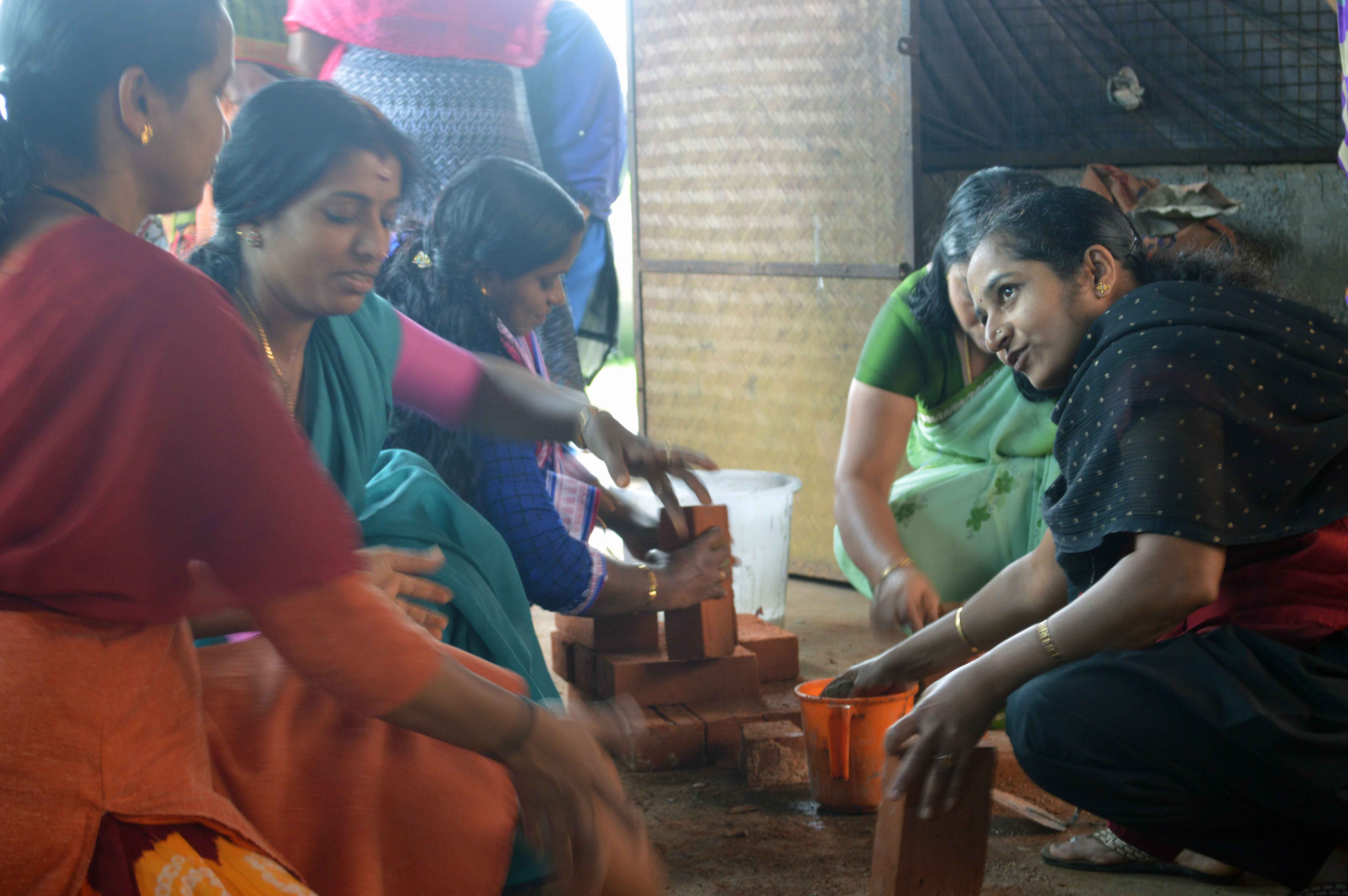 Mananthavady women cleaning and setting up stacks of bricks in preparation for the next layer of the kiln.