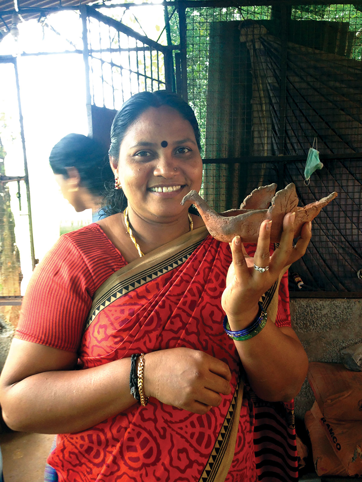 Meaghan’s student shows her Bird Puja Lamp post-firing. Mananthavady, Kerala, India, 2015. Photo by author.