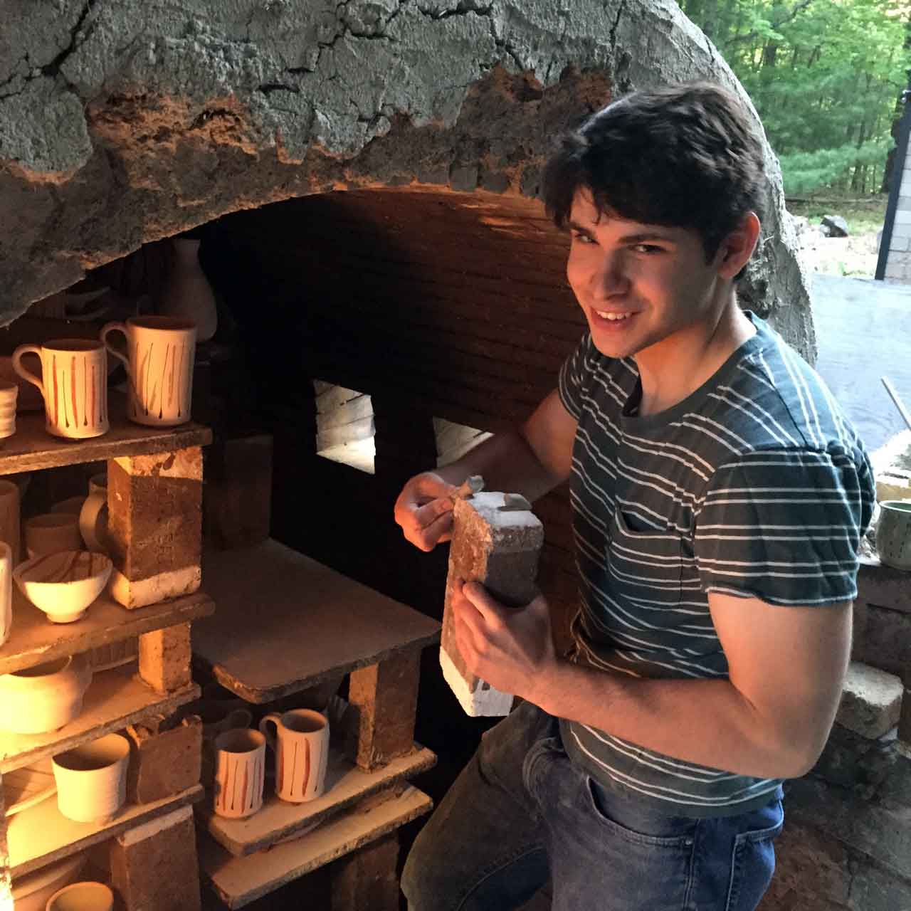 Kevin Beckerman helps to load the kiln; here he's putting wadding between the bricks and shelves so that they don't stick together during the firing.