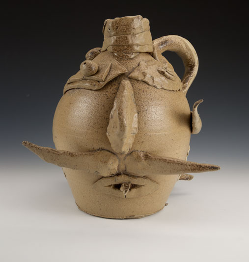 A collaborative piece by McCarthy and a student, Ben Z., made as a modern reinterpretation of face jugs. Wheel-thrown stoneware, altered, wood-fired to Cone 10, salt-glazed, 13.5 x 10 x 9 in.