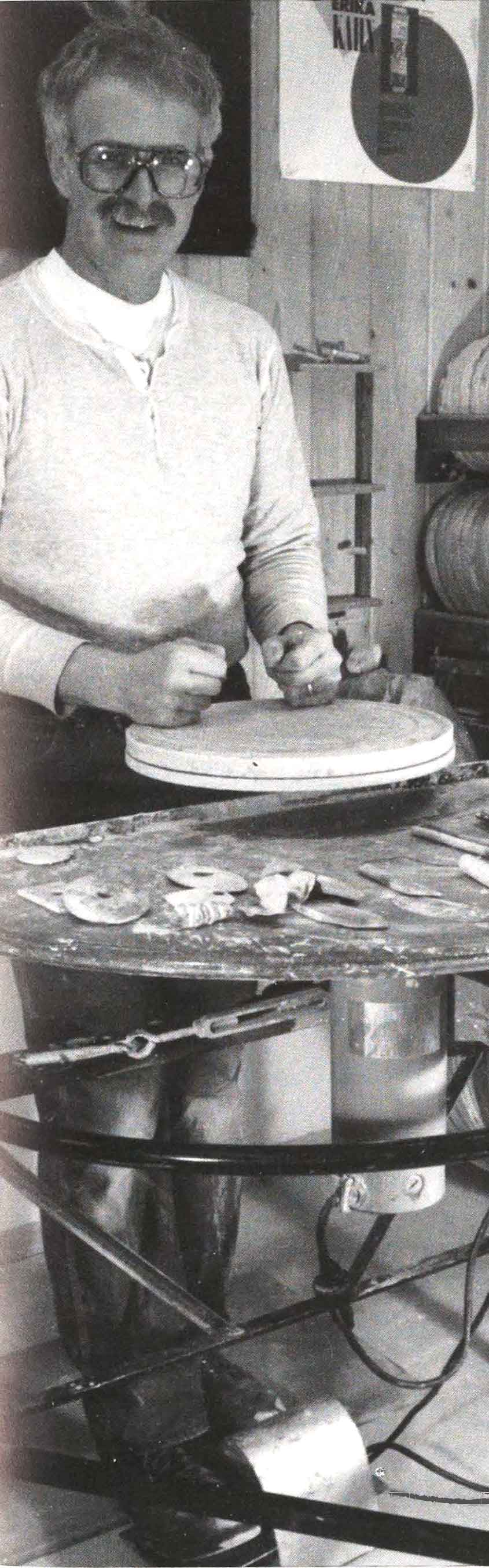 John Glick at his potter&#039;s wheel, raised to enable throwing pots standing, rather than sitting, for back health.