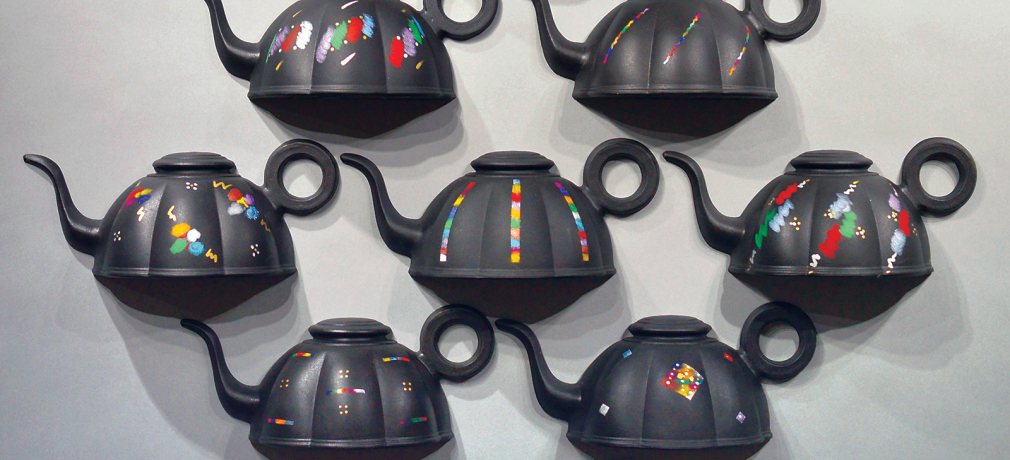 Jonathan Kaplan. Teapot Grid, 2016. Detail of nine teapot forms finished with underglazes, cold finishes, and wall-mounted.