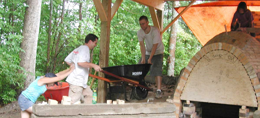 Simon Levin is assisted up the side berm during the construction of the anagama kiln at Corning Community College, Corning, New York, in 2003. Photograph by Dr. Robert Tichane. 
