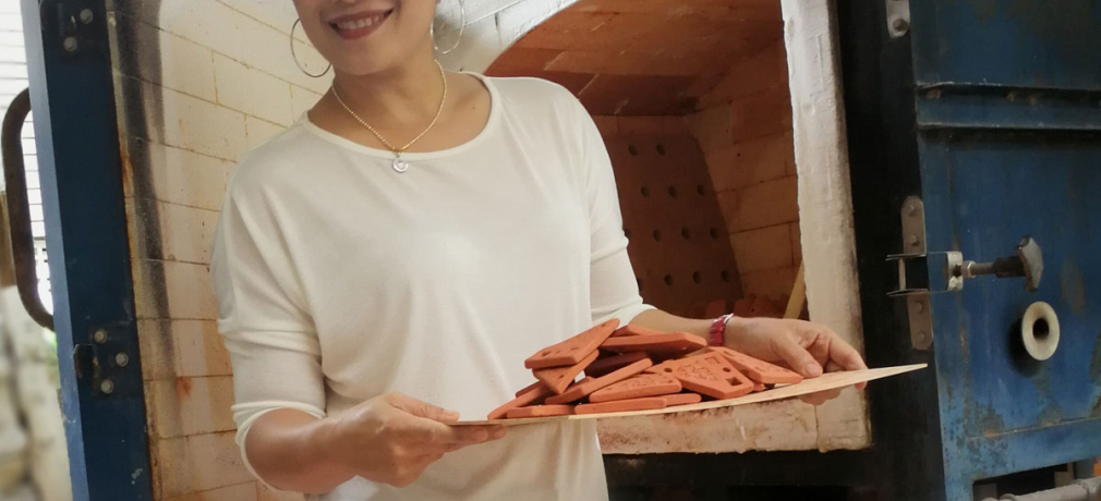 Wanphet unloads a kiln at her home workshop, 2018.