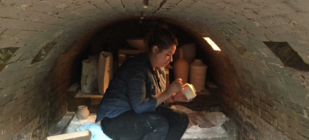 Jacklyn Scott helps load Muller's kiln. 