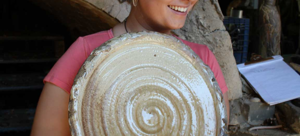 Muller's daughter Jacklyn shows off her platter during the unloading of the kiln.