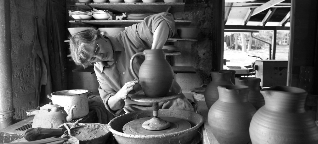 Jane Herold bowing handles on jugs in her studio, Palisades, New York. Photo by Susan Stava.