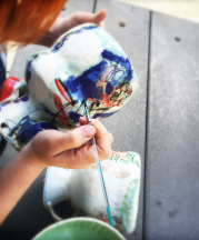 Cambric applies her luster overglaze to her footed bowls. Photo by artist, 2015.