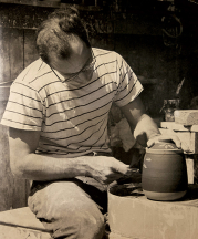 Harry Holl at his wheel carving a vase in the sgraffito technique, 1960s.