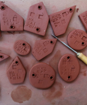 Holes are drilled in clay souvenirs that read "Na Kai Khia,” the name of a village in Thailand, 2018.