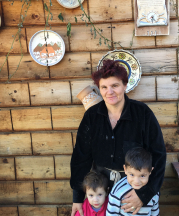 Alina Iorga, 2017, outside of her home with her grandchildren.
