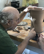 Guy Wolff shows students in his September 2019 workshop at the Truro Center for the Arts at Castle Hill his method for attaching handles. 