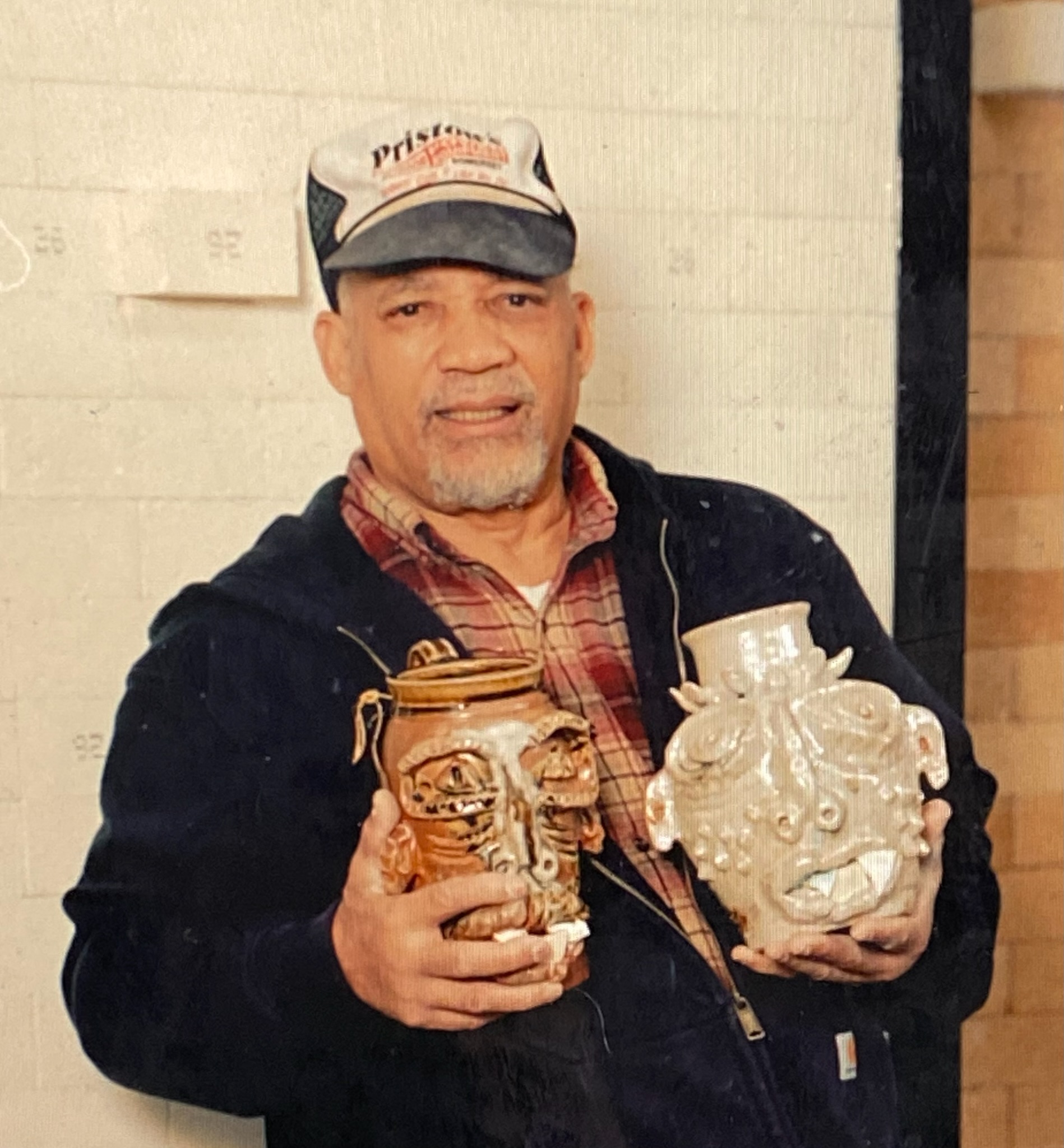 Jim McDowell removing face jugs out of the kiln, photo credit Peyton Fulford.