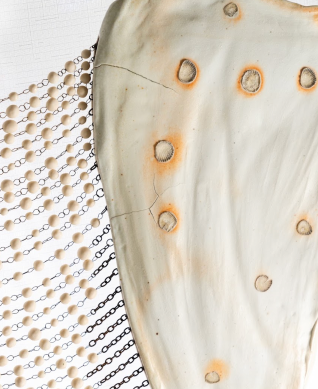 Detail. On Their Shoulders, 365 porcelain beads hung between two sculpted porcelain shoulder blades, and Enduring Light, 7 floating porcelain luminaries in a blown glass bowl with shards of broken porcelain on a pedestal. Photo courtesy of Joseph Robinson.