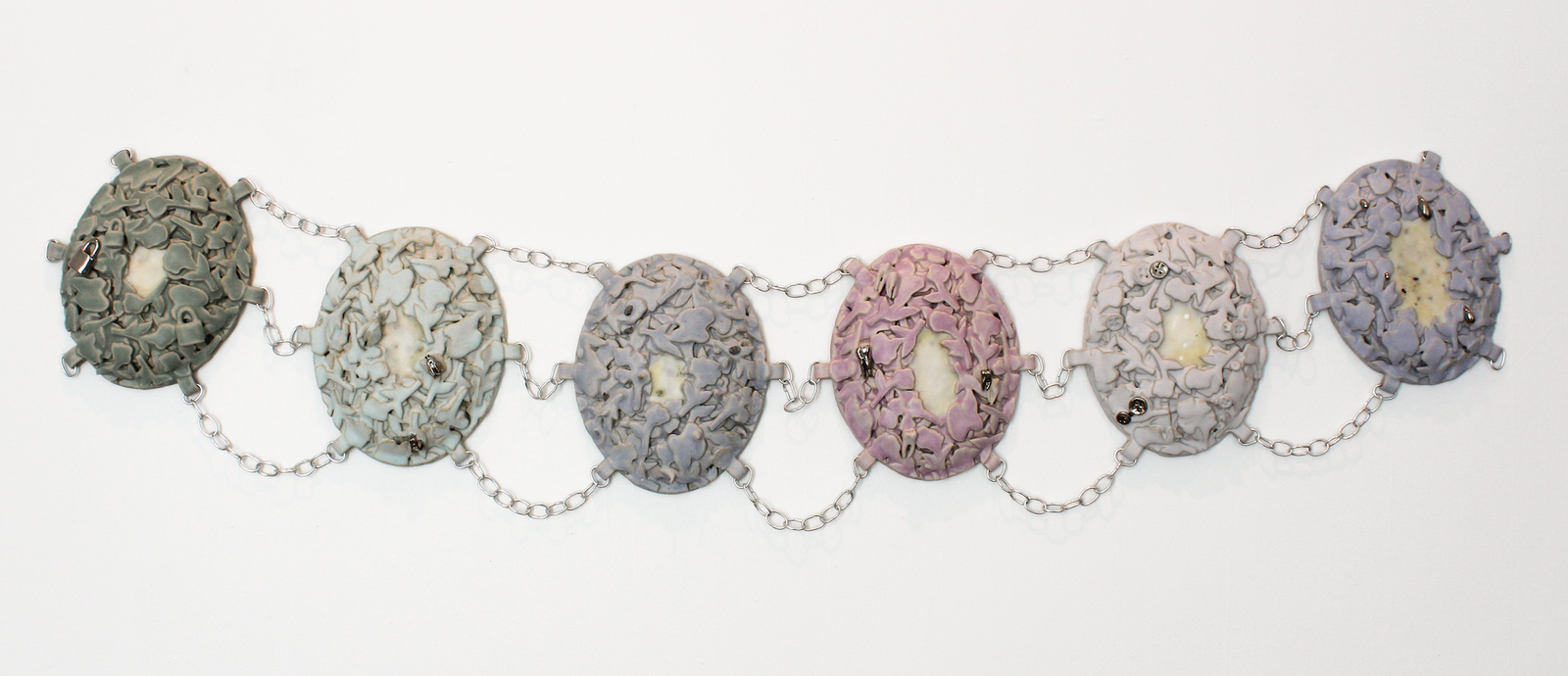 Abbey Peters, Heirloom: To Hide and To Hold, 2025, ceramic, glaze, luster, wire, beeswax, abortifacient herbs, birth control and morning-after pills, 3" x 16" x 72"